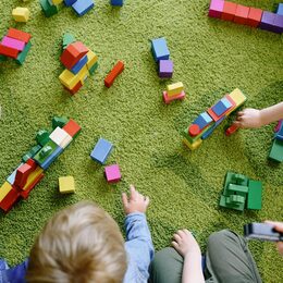 Kinder mit Spielzeug auf einem Teppich