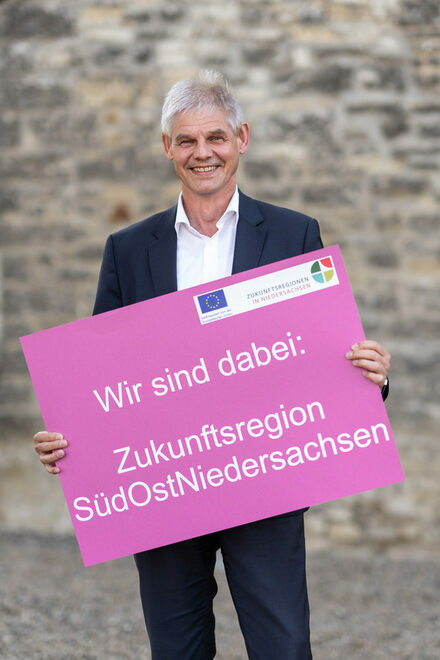 Bild von Oberbürgermeister Frank Klingebiel mit Plakat der Zukunftsregion