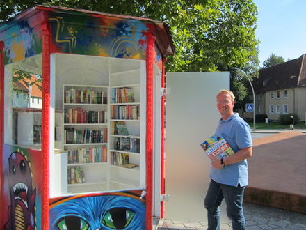 Benjamin Speitelsbach (Pastor Evangelisch-Freikirchliche Gemeinde Salzgitter) nimmt den öffentlichen Bücherschrank auf dem Martin-Luther-Platz in Augenschein.